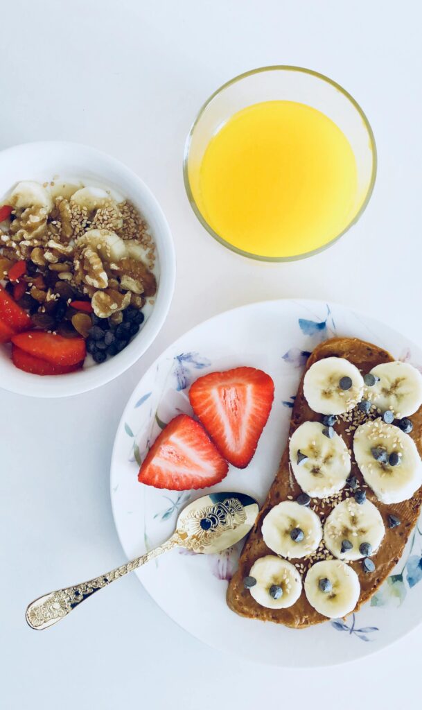 healthy breakfast of toast and yogurt parfait with orange juice