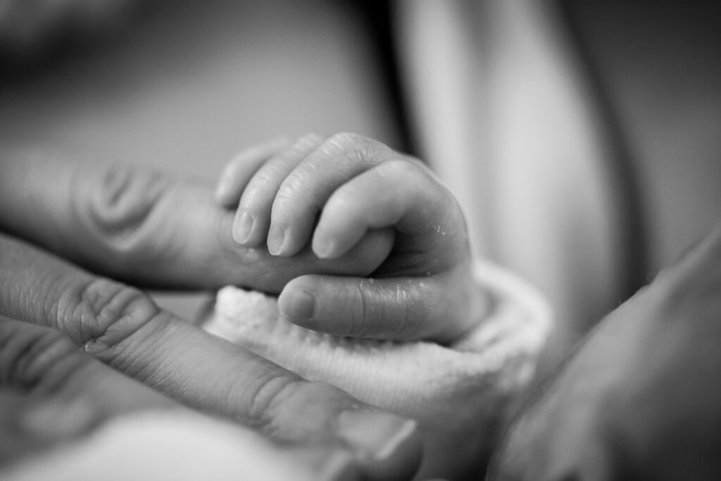 newborn hand holding mother's finger