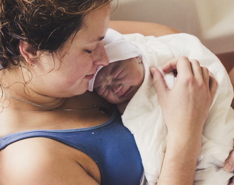 woman holding newborn after birth