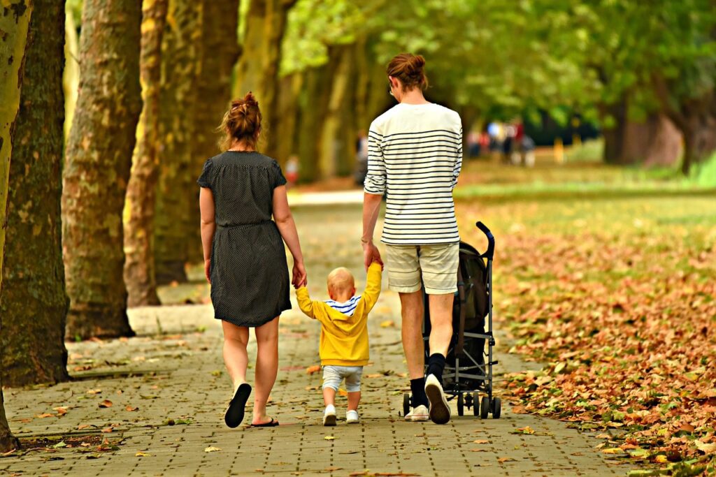 family walking with toddler and baby in stroller postpartum walking guide